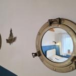 Room with view through round window, bed and window with curtain.