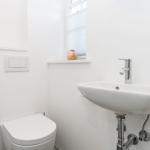 Badezimmer mit Toilette, Waschbecken und Fenster