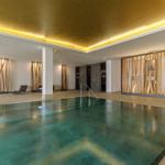 Innenpool mit Holzverkleidung und goldenem Deckenlicht.