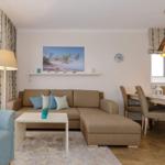 Wohn- und Essbereich mit Sofa, Tisch und Stühlen.