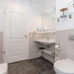 Badezimmer mit Waschbecken, Toilette und Heizung.