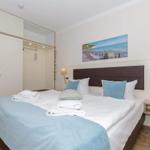 Schlafzimmer mit Bett, Kleiderschrank und Wandbild an der Wand.