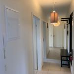 Flur mit Tür zu Schlafzimmer, Hängelampe und Bänkchen