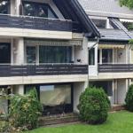 Ferienhaus mit Balkonen und Garten. Modernes Gebäude mit großen Fenstern.