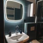 Badezimmer mit Waschbecken, Spiegel und Toilette