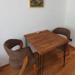 Holztisch mit zwei Stühlen und Wandbild im Essbereich.