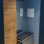 Schlafzimmer mit Holzschrank und Sitzbank an der Wand