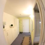 Flur mit weißen Schränken, Teppich und gelber Wand