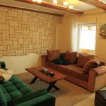 Wohnzimmer mit Schlafsofa und grünem Samtsofa