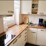 Küche mit Holzoberfläche, Spüle, Kaffeemaschine und Wasserkocher.