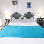 Schlafzimmer mit Doppelbett, zwei Nachttischen und Fenster.