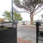 Von der Terrasse aus sieht man die Straße, Bäume und das Meer.