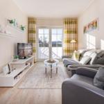 Wohnzimmer mit Sofa, Fernseher und Terrassentür.