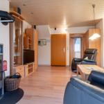 Wohnzimmer mit Holzboden, Kamin, Ledersofa und Fernseher.