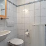 Badezimmer mit Waschbecken, Toilette und Heizkörper