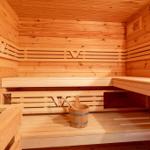 Sauna mit Holzbank und Eimer mit Kelle