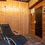 Saunaraum mit zwei Liegestühlen und Holzwandverkleidung.