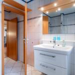 Badezimmer mit Waschbecken, Spiegel und Dusche