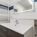 Badezimmer mit Waschbecken, Spiegel und Heizkörper