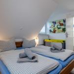 Schlafzimmer mit Doppelbett, Spielwand und angrenzender Badewanne.
