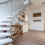 Moderne Wohnung mit Treppe, Essbereich und Eingangsbereich.