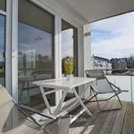 Terrasse mit Tisch, zwei Stühlen und Blick auf Wohngebiet.