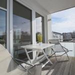 Terrasse mit Tisch, zwei Stühlen und Blick auf Wohngebiet.