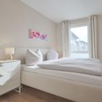 Schlafzimmer mit Doppelbett, Nachttisch und Fenster