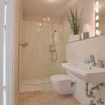 Badezimmer mit Dusche, Waschbecken und Toilette.