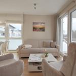 Wohn- und Essbereich mit Sofa, Sessel und großem Fensterblick.