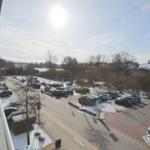 Aussicht auf Parkplatz mit Autos und verschneite Bäume