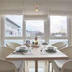 Esszimmer mit Tisch und Stühlen, großes Fenster mit Blick auf Außenbereich.