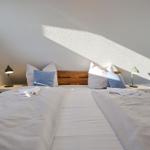 Zimmer mit Doppelbett, Holzkopfteil und zwei Nachttischen mit Lampen.