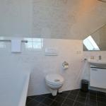 Badezimmer mit Badewanne, Toilette und Waschbecken.