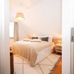 Schlafzimmer mit Bett, Nachttisch und Decke.