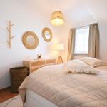 Schlafzimmer mit Bett, Nachttisch, Lampe und Fenster