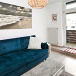 Ein Wohnzimmer mit blauem Sofa, Glas-Tür und Wandbild