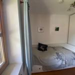 Bedroom with bed, window, and wardrobe.