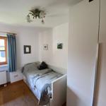 A bedroom with bed, window, curtain, and wardrobe.