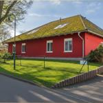 Rotes Haus mit grünem Dach und Garten. Hausnummer 3a.