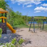 Kinderbereich mit Rutsche und Schaukel am See