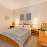 Schlafzimmer mit Bett, Nachttischen und Schreibtisch.