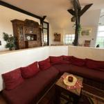 Wohnbereich mit L-förmigem Sofa und Holzmöbeln.