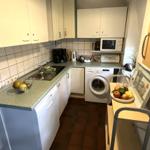 Küche mit Spüle, Waschmaschine und Mikrowelle.