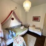 Schlafzimmer mit zwei Betten, Kronleuchter und Kleiderschrank