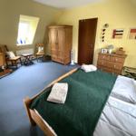 Schlafzimmer mit Bett, Kleiderschrank und Fenster