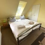 Doppelbettzimmer mit Dachschräge, Fenster, Kleiderschrank und Heizung.