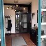 Eingangsbereich mit Tür, Kleiderständer und Bodenbelag