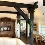 Raum mit dunklen Holzbalken, antikem Schrank und rustikalem Mobiliar.