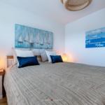 Schlafzimmer mit Bett, Nachttisch und Wanddekoration.